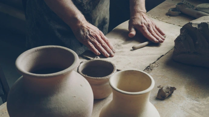 A potter works on his clay pieces.